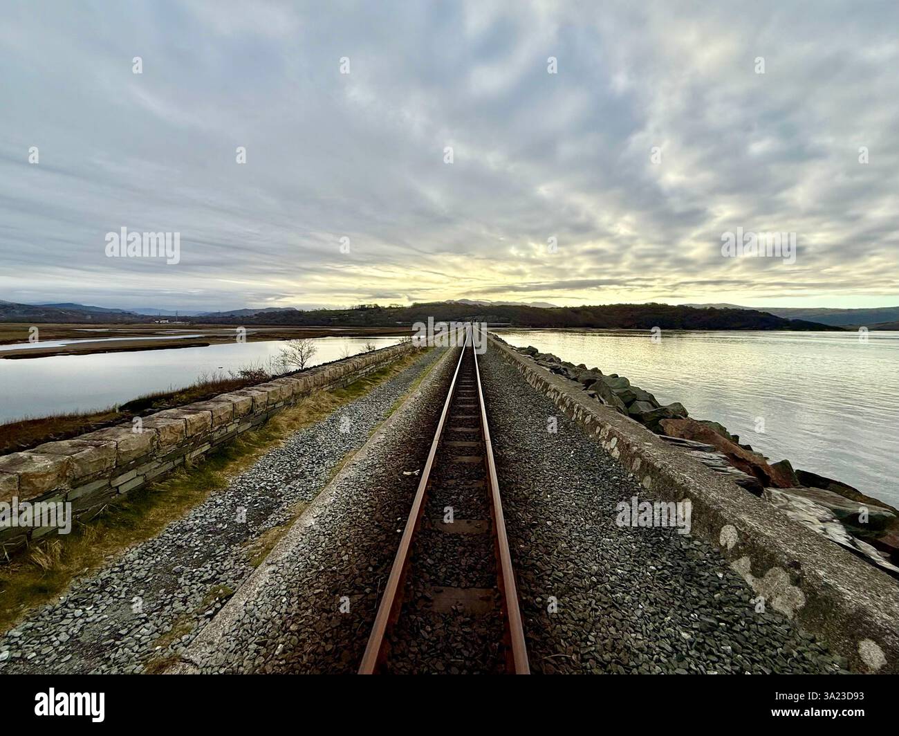 Blick nach Osten entlang einer geraden Eisenbahnstrecke, die sich in die Ferne mit einem wunderschönen Himmel erstreckt - Smartphone-aufgenommenes Stockfoto