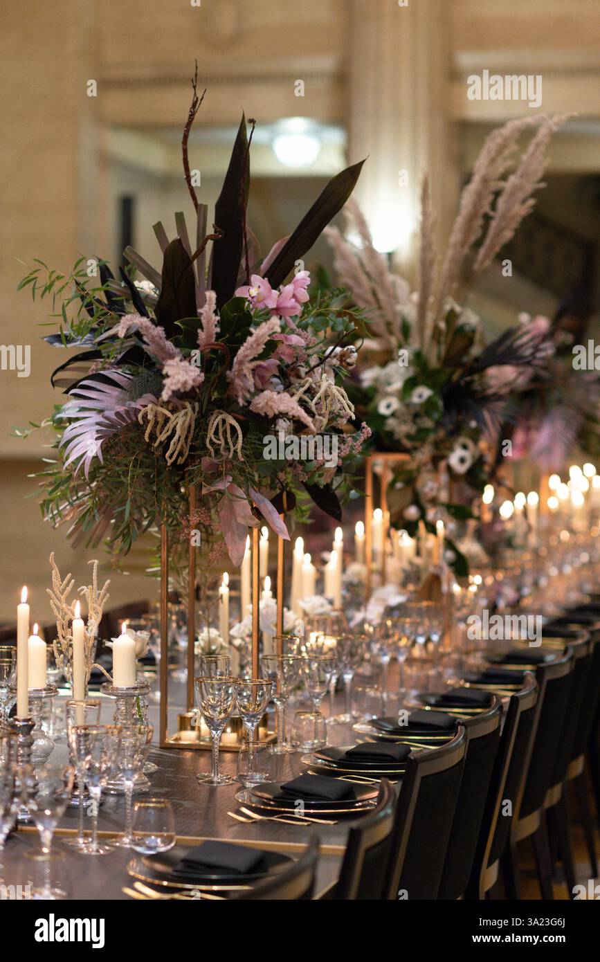 Eleganter Tisch mit Kerzenlicht und Blumendekor Stockfoto