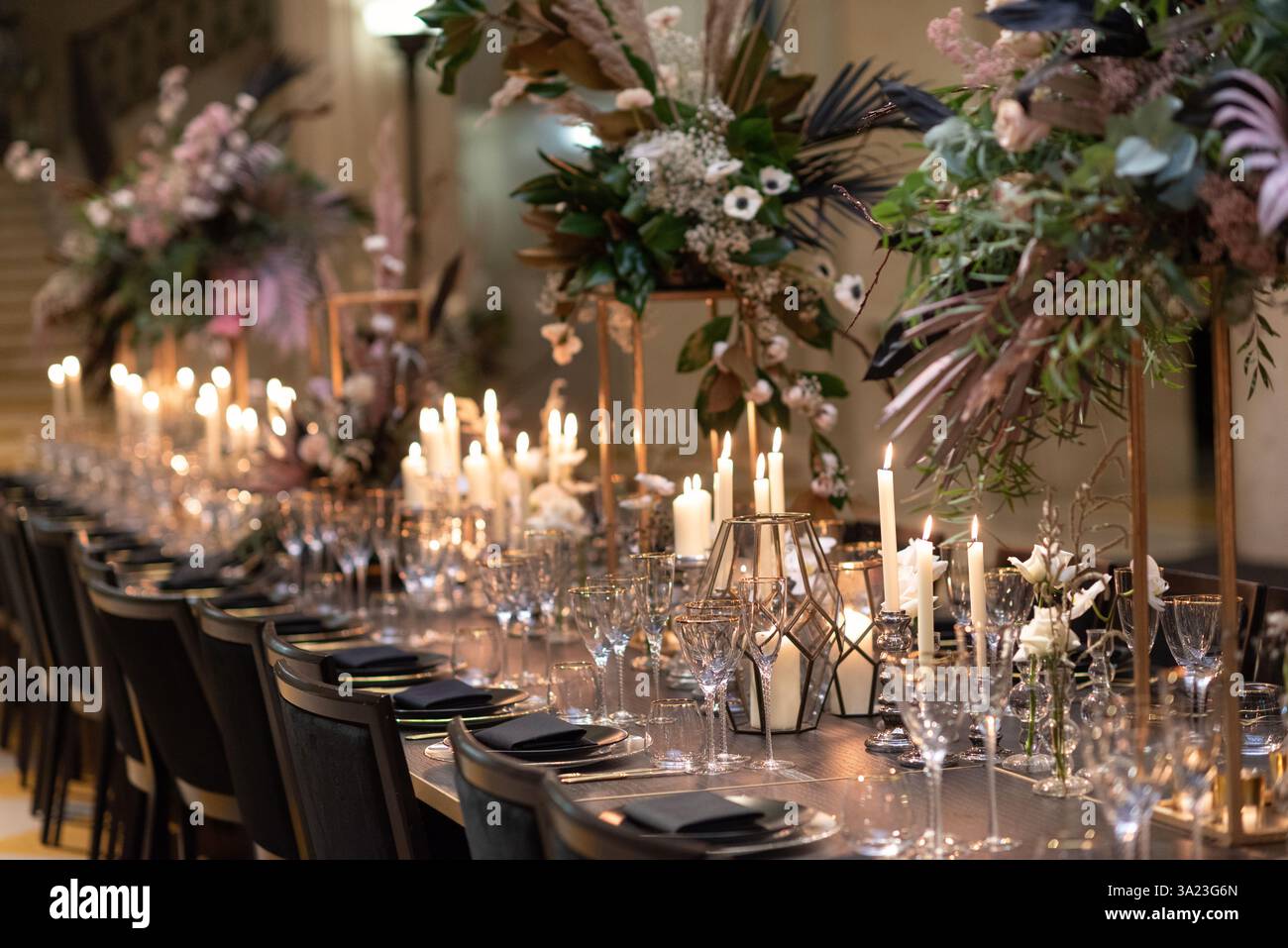 Eleganter Tisch mit Kerzenlicht und Blumendekor Stockfoto