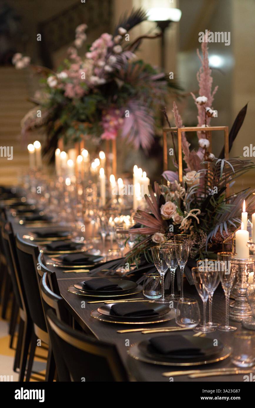 Eleganter Tisch mit Kerzenlicht und Blumendekor Stockfoto
