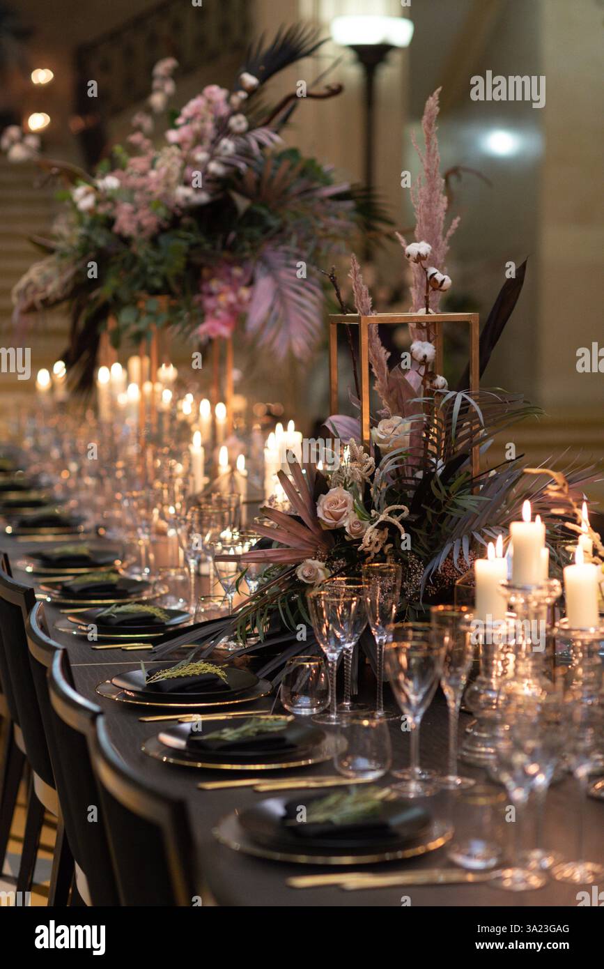 Eleganter Tisch mit Kerzenlicht und Blumendekor Stockfoto