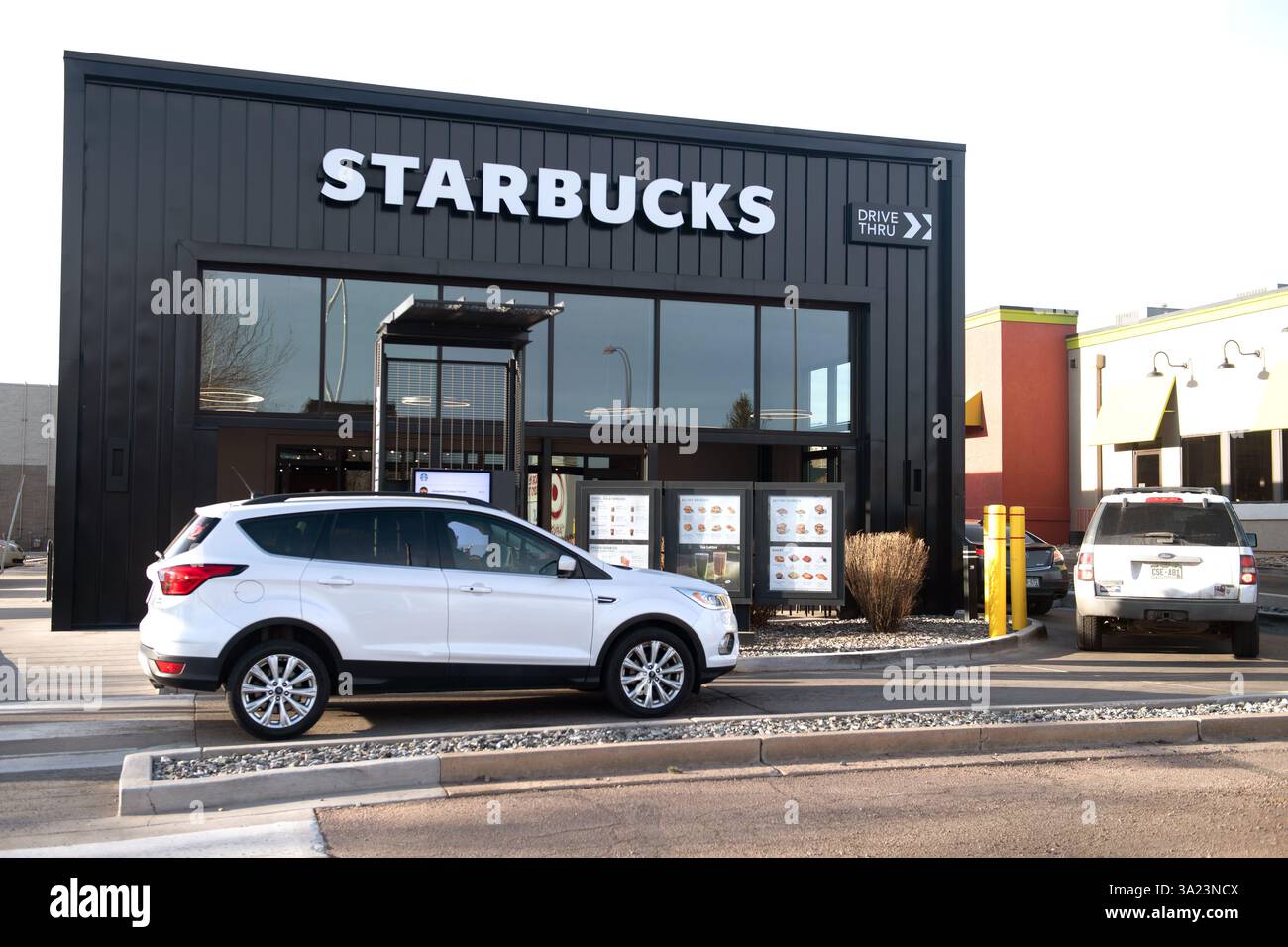 Autos stehen in der Starbucks Drive Thru Lane bei einem Starbucks in Colorado Springs, Colorado. Am frühen Morgen an einem Arbeitstag. Stockfoto