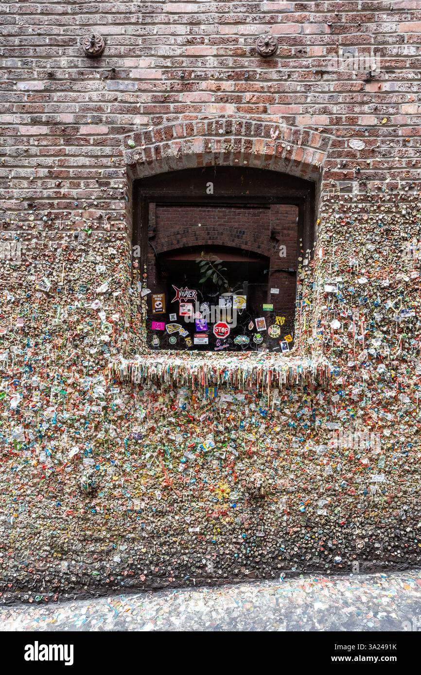 Touristen kleben Kaugummi an der Gum Wall von Seattle, einer skurrilen Tradition, die sich zu einem bunten, wenn auch klebrigen Wahrzeichen entwickelt hat. Stockfoto