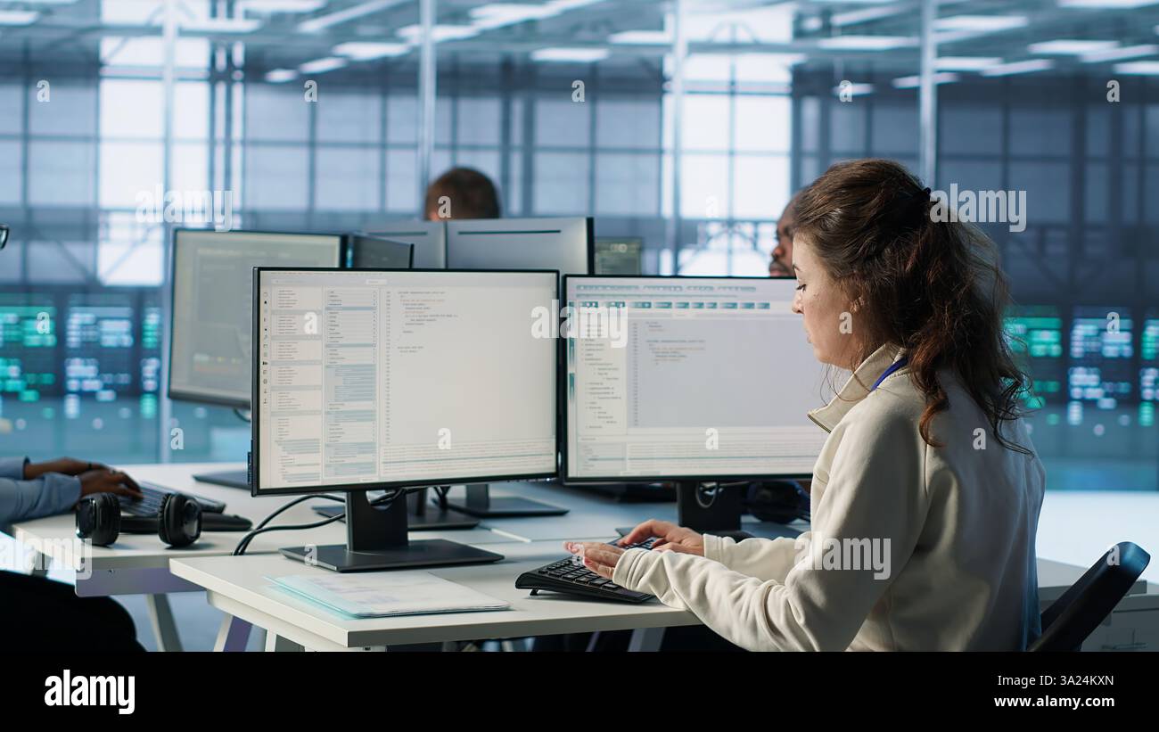 Manager leitet multiethnische Teams, die im Rechenzentrum arbeiten und Ankündigungen machen. Teamleiter bespricht mit Mitarbeitern die Überwachung des Energieverbrauchs über Serverkomponenten hinweg, Kamera A Stockfoto