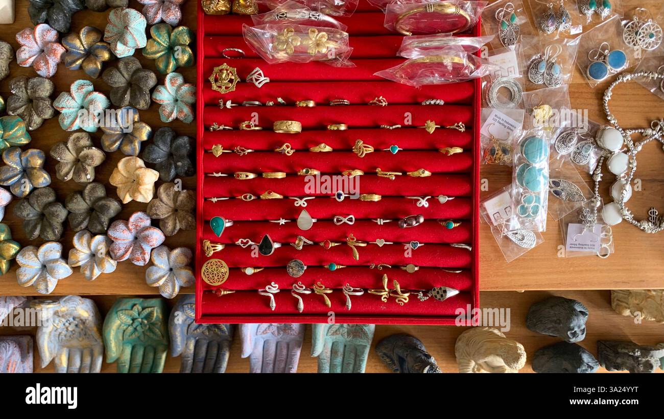 Farbenfroher handgemachter Schmuck auf Balis Ubud Market. Ringe, Ohrringe und Armbänder zeigen einzigartige balinesische Kunst. - Smartphone-aufgenommenes Stockfoto