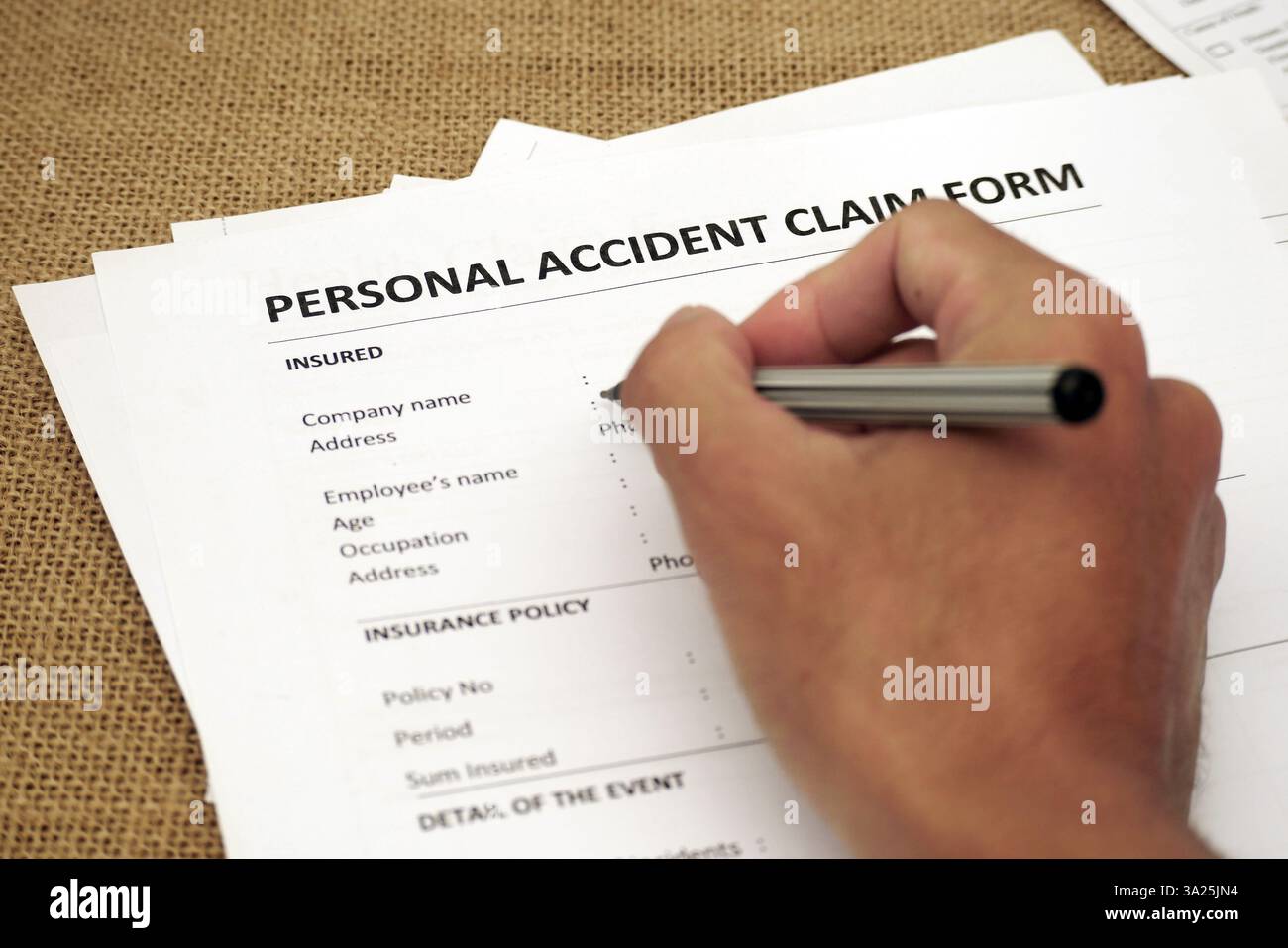 Eine Hand, die ein Antragsformular für persönliche Unfälle ausfüllt, das die Dokumentation, die Versicherungsabwicklung und den finanziellen Schutz nach einem Vorfall symbolisiert Stockfoto