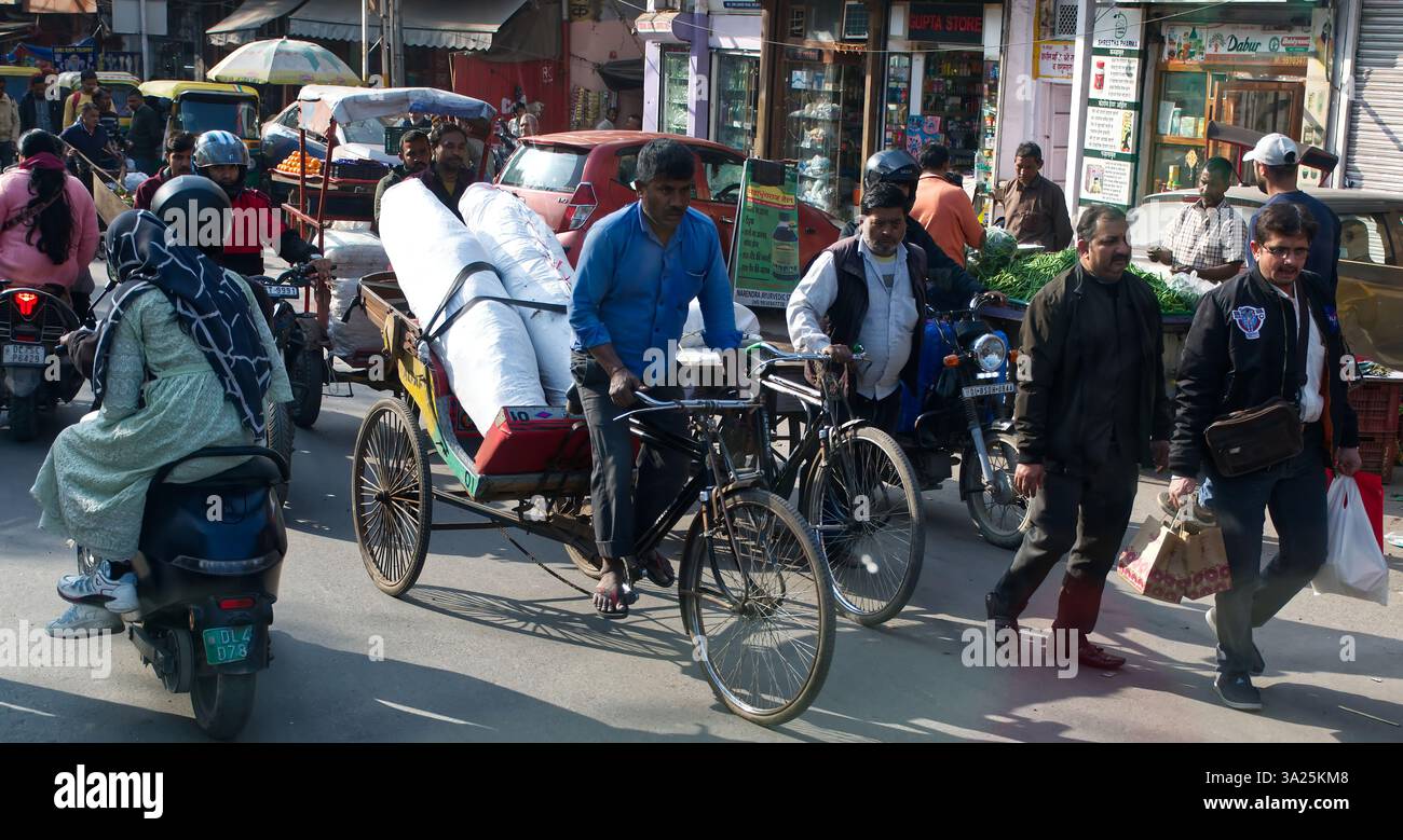 Belebte indische Straßenszene mit Rikscha und Motorrädern. Delhi, Indien. Stockfoto
