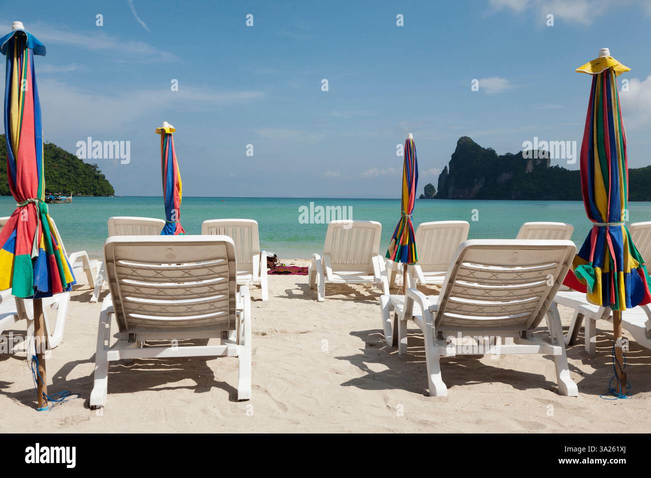 Liegestühle und Sonnenschirme an einem Strand auf den Andamaneninseln vor der Küste Thailands. Stockfoto
