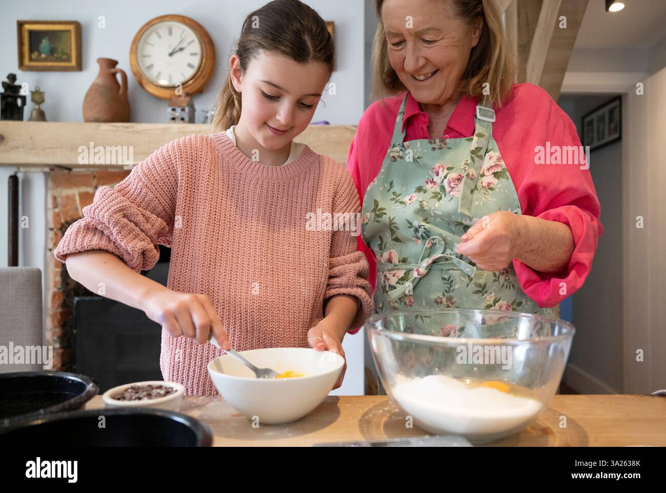Großmutter und Enkelin backen zusammen in der Küche. Stockfoto