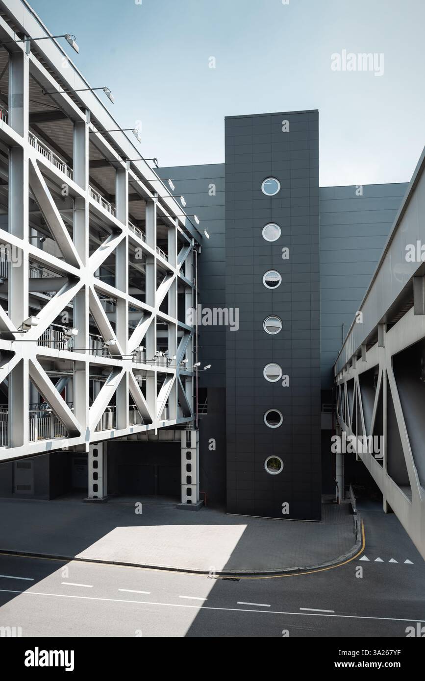 Modernes Gebäude in der Stadt. Mehrstöckige Brücke, die zwei Gebäude verbindet. Leere Stadtstraße an einem sonnigen Tag. Stockfoto