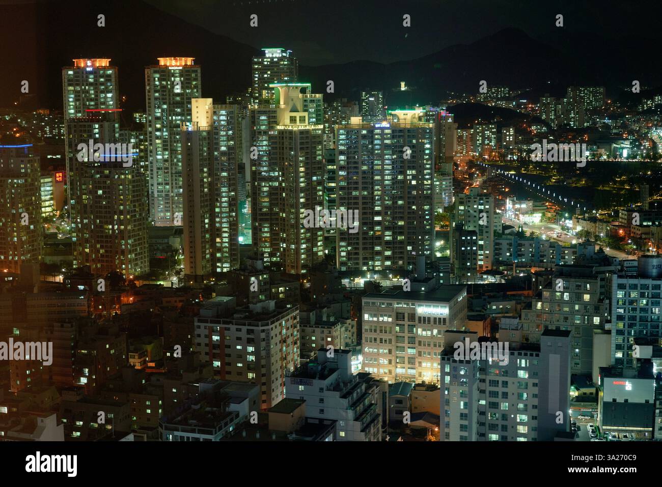 Nächtliche Stadtlandschaft einer pulsierenden Stadt mit beleuchteten Wolkenkratzern und dichtem Stadtbild. Busan, Korea Stockfoto