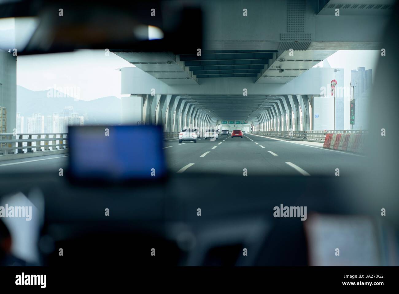 Blick aus dem Inneren eines Autos, das auf einer Autobahn durch einen modernen Betontunnel unter einem bewölkten Himmel fährt. Busan, Korea Stockfoto