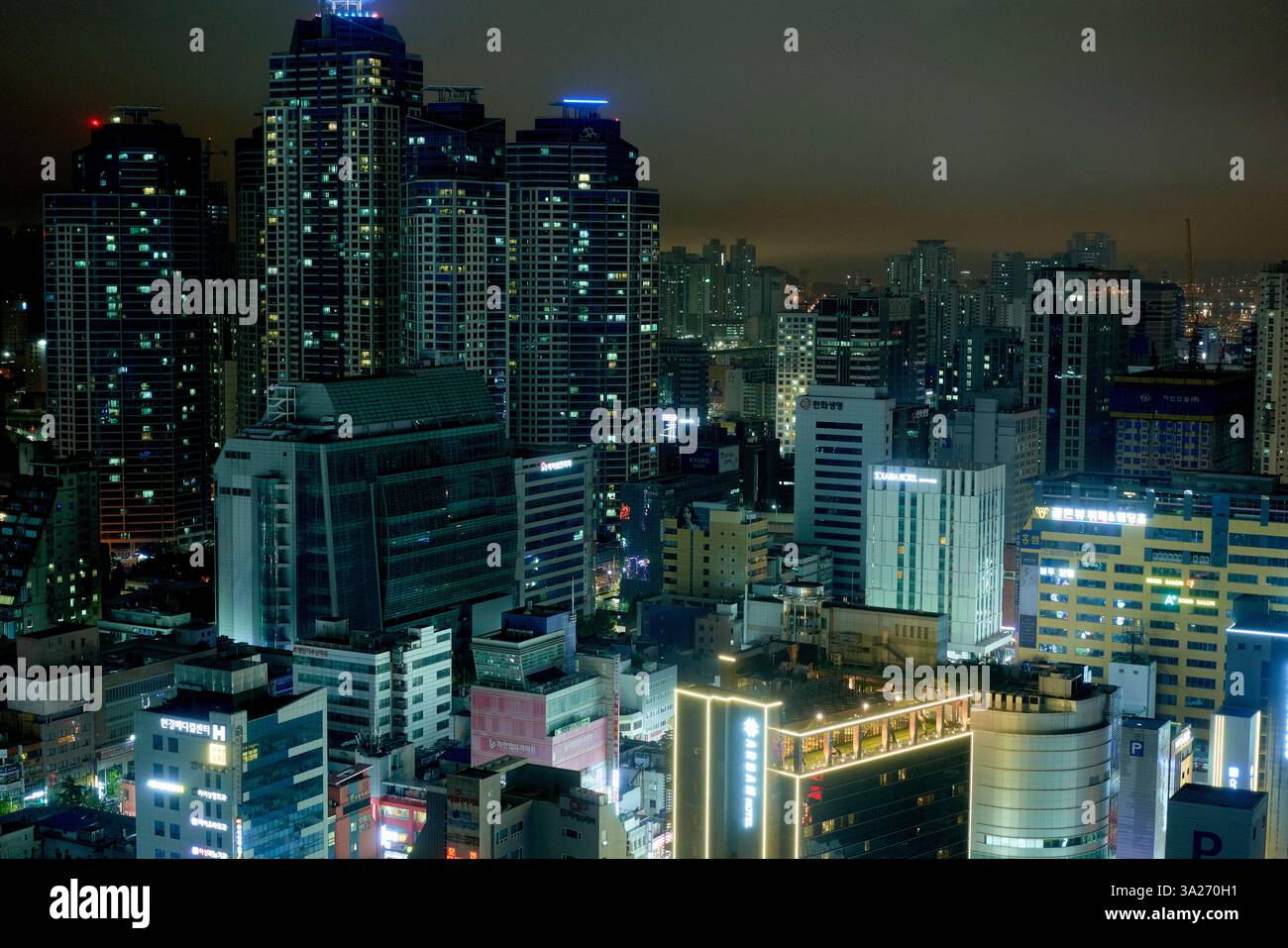 Beleuchtete Skyline der Stadt mit zahlreichen hohen Gebäuden unter einem Nachthimmel. Busan, Korea Stockfoto