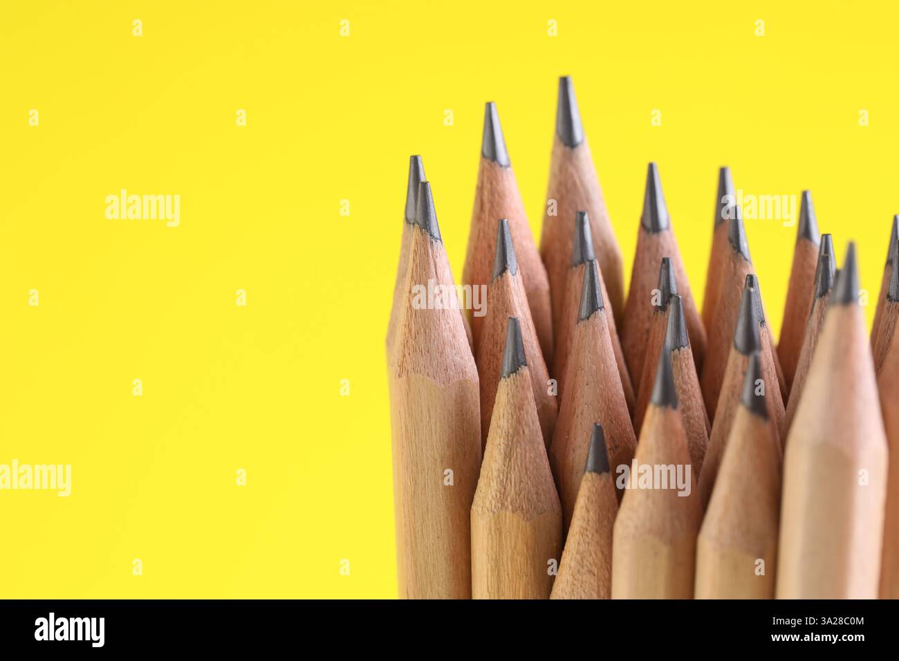 Viele Graphitstifte auf gelbem Hintergrund, Nahaufnahme. Leerzeichen für Text Stockfoto
