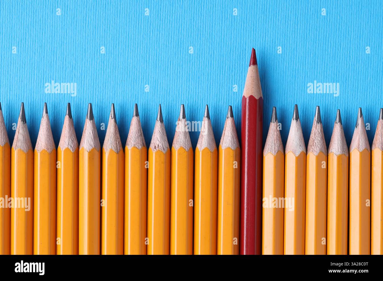 Ein roter Bleistift unter Graphit auf hellblauem Hintergrund, Draufsicht Stockfoto