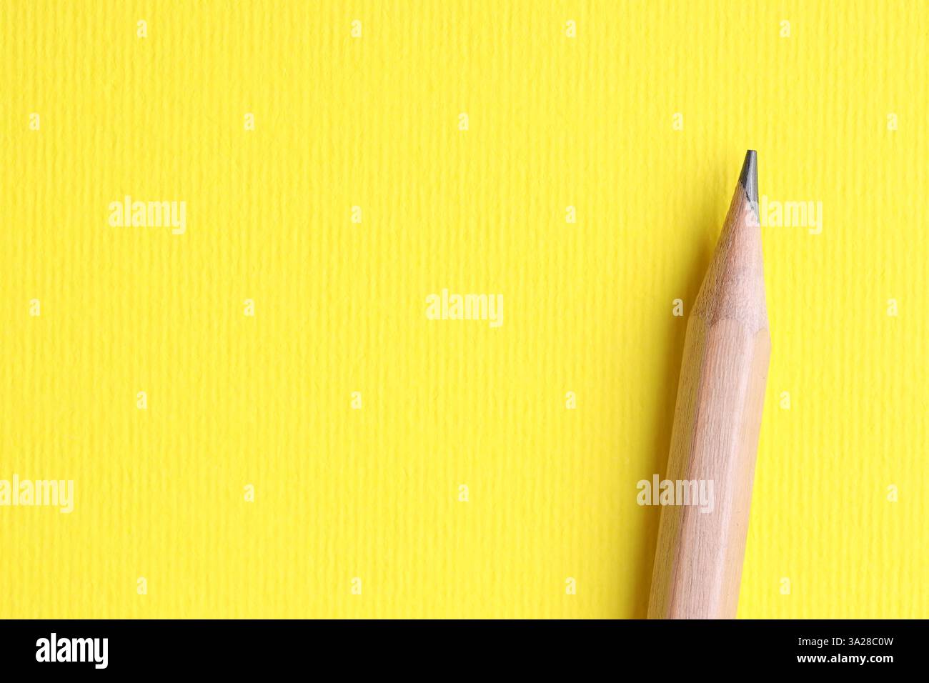 Ein Bleistift auf gelbem Hintergrund, Draufsicht. Leerzeichen für Text Stockfoto