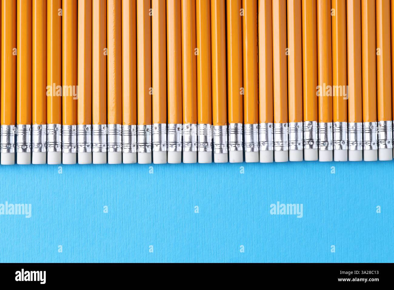 Viele Bleistifte auf hellblauem Hintergrund, Draufsicht. Leerzeichen für Text Stockfoto