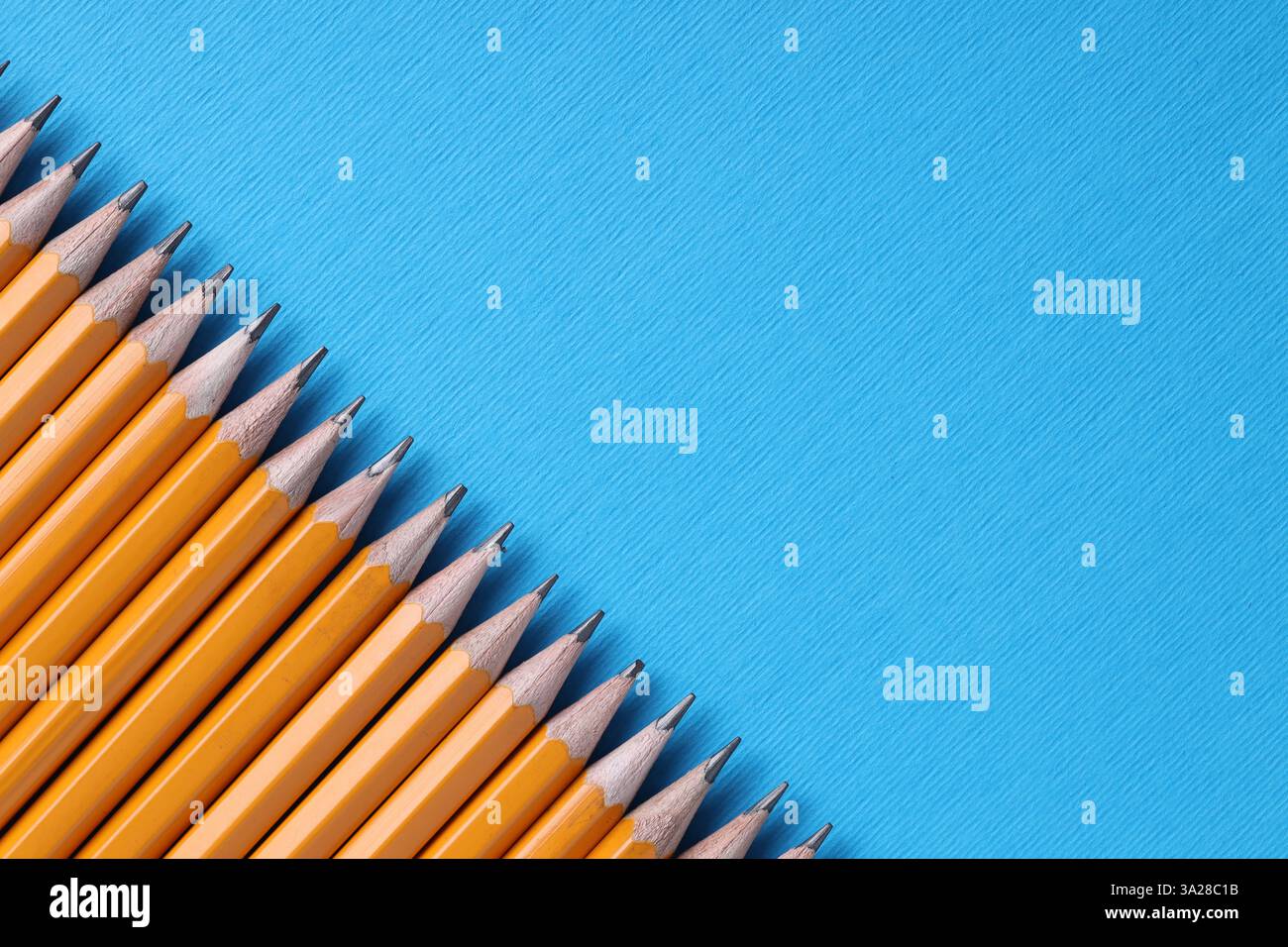 Viele Bleistifte auf hellblauem Hintergrund, Draufsicht. Leerzeichen für Text Stockfoto