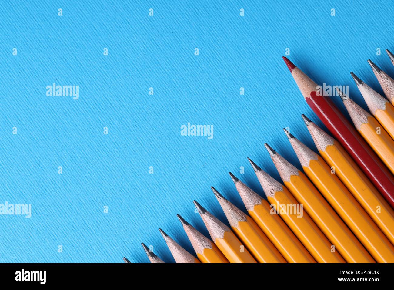 Ein roter Bleistift unter Graphit auf hellblauem Hintergrund, Draufsicht. Leerzeichen für Text Stockfoto