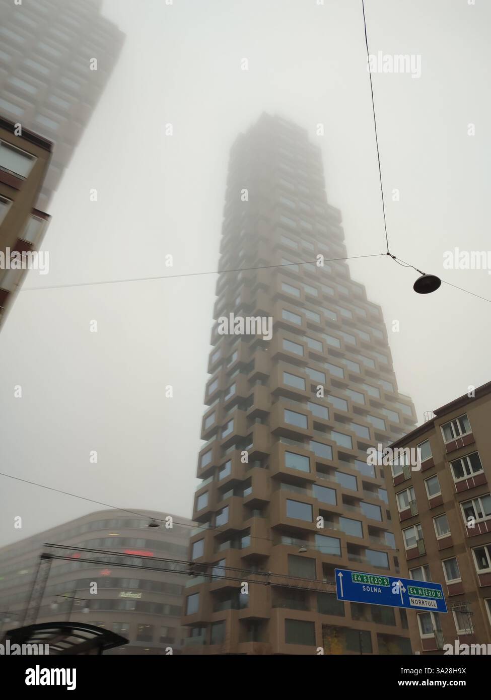 Moderne Architektur der Wohntürme von Norra Tornen, die in Stockholm, Schweden, in dichtem Nebel verschwinden - Smartphone-aufgenommenes Stockfoto