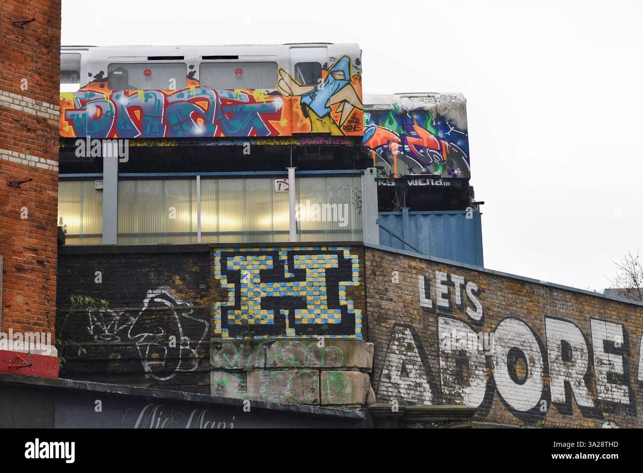 Lassen Sie uns Graffiti-bedeckte U-Bahn-Wagen auf dem Dach der Great Eastern Street, Shoreditch, London lieben Stockfoto