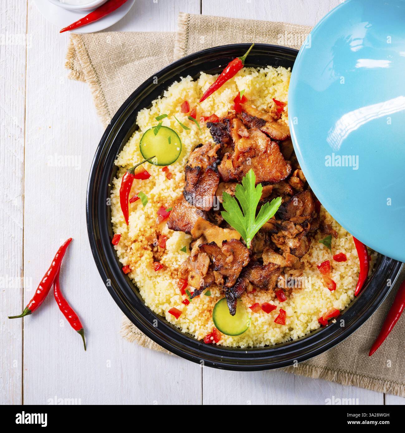 Tajin mit Couscous, Gemüse und Fleisch auf weißem Hintergrund Stockfoto