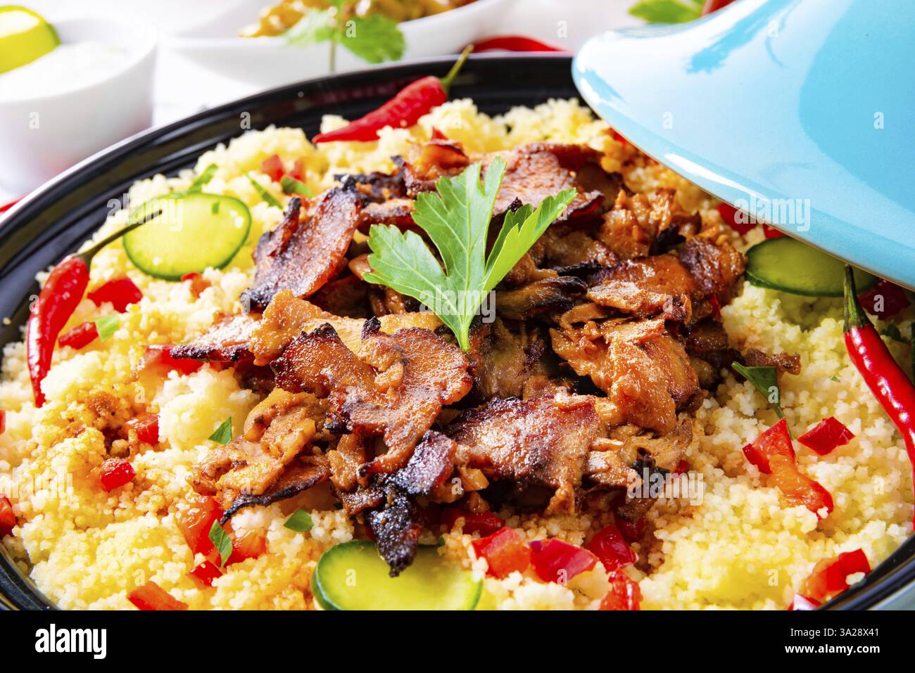 Tajin mit Couscous, Gemüse und Fleisch auf weißem Hintergrund Stockfoto