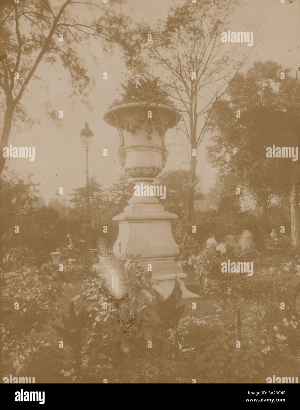 Dieses Bild der Tuilerien-Gärten fängt die natürliche Schönheit und das strukturierte Design des öffentlichen Parks ein. Atget betont die Balance zwischen Natur und Architektur in diesem berühmten Pariser Garten. Stockfoto