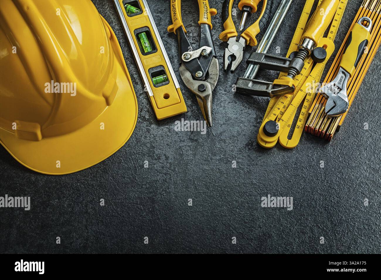 Satz gelber Bauwerkzeuge auf schwarzem Hintergrund Stockfoto