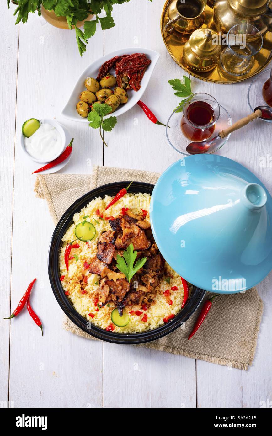 Tajin mit Couscous, Gemüse und Fleisch auf weißem Hintergrund Stockfoto