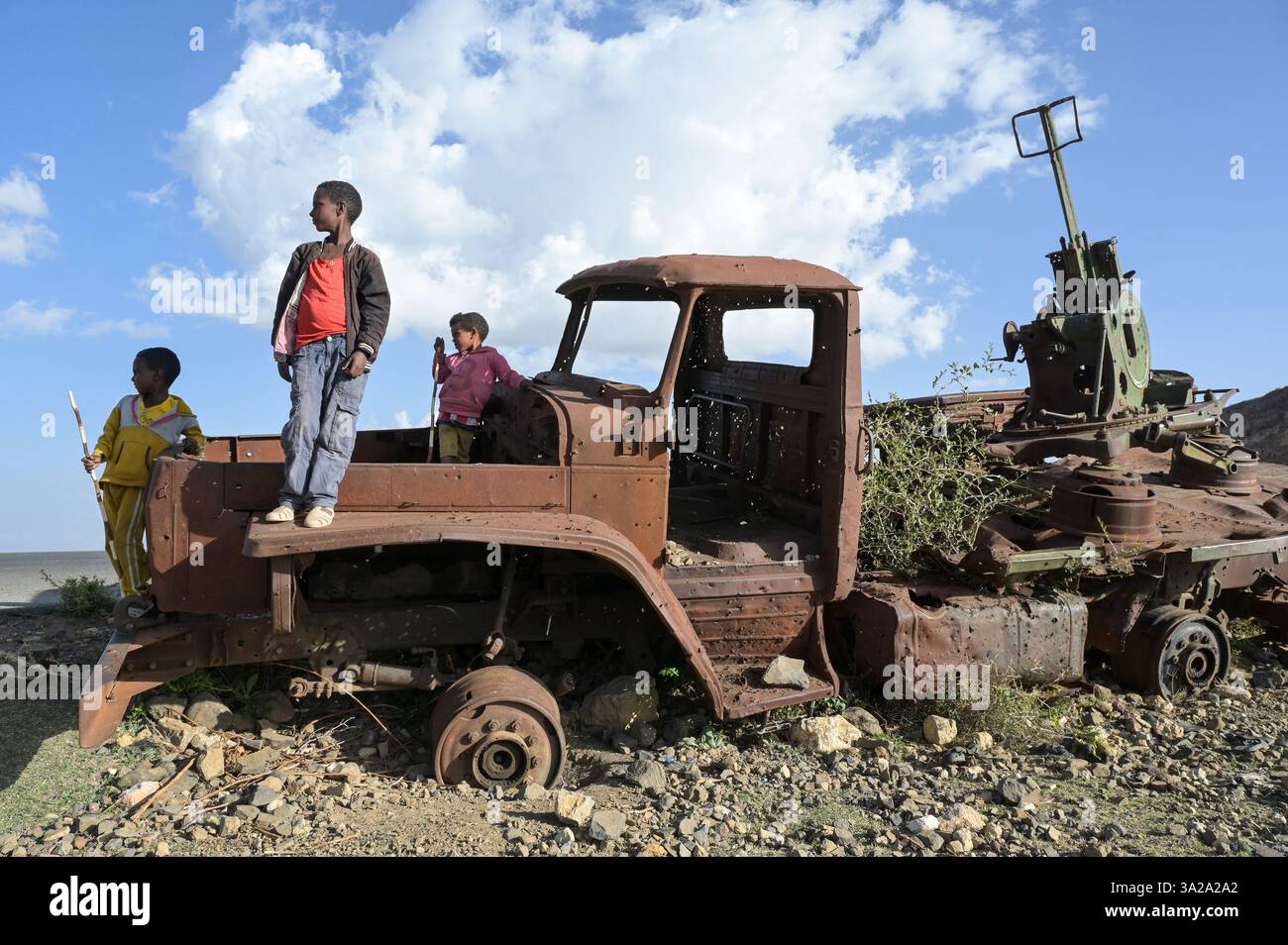 ÄTHIOPIEN, Tigray, Straße nach Mekelle, Tigray Krieg 2020-2022 zwischen Truppen, die mit der äthiopischen Bundesregierung und Eritrea verbündet sind, und der Tigray Volksbefreiungsfront TPLF, Kinder spielen auf zerstörtem russischen Artilleriewagen Ural 4320 der eritreischen Truppen / Äthiopien, Tigray, Folgen des Tigray Kriege 2020-2022, Distrikt Yechila, im Krieg von der TPLF zerstörte Armeefahrzeuge der eritreischen Truppen Stockfoto