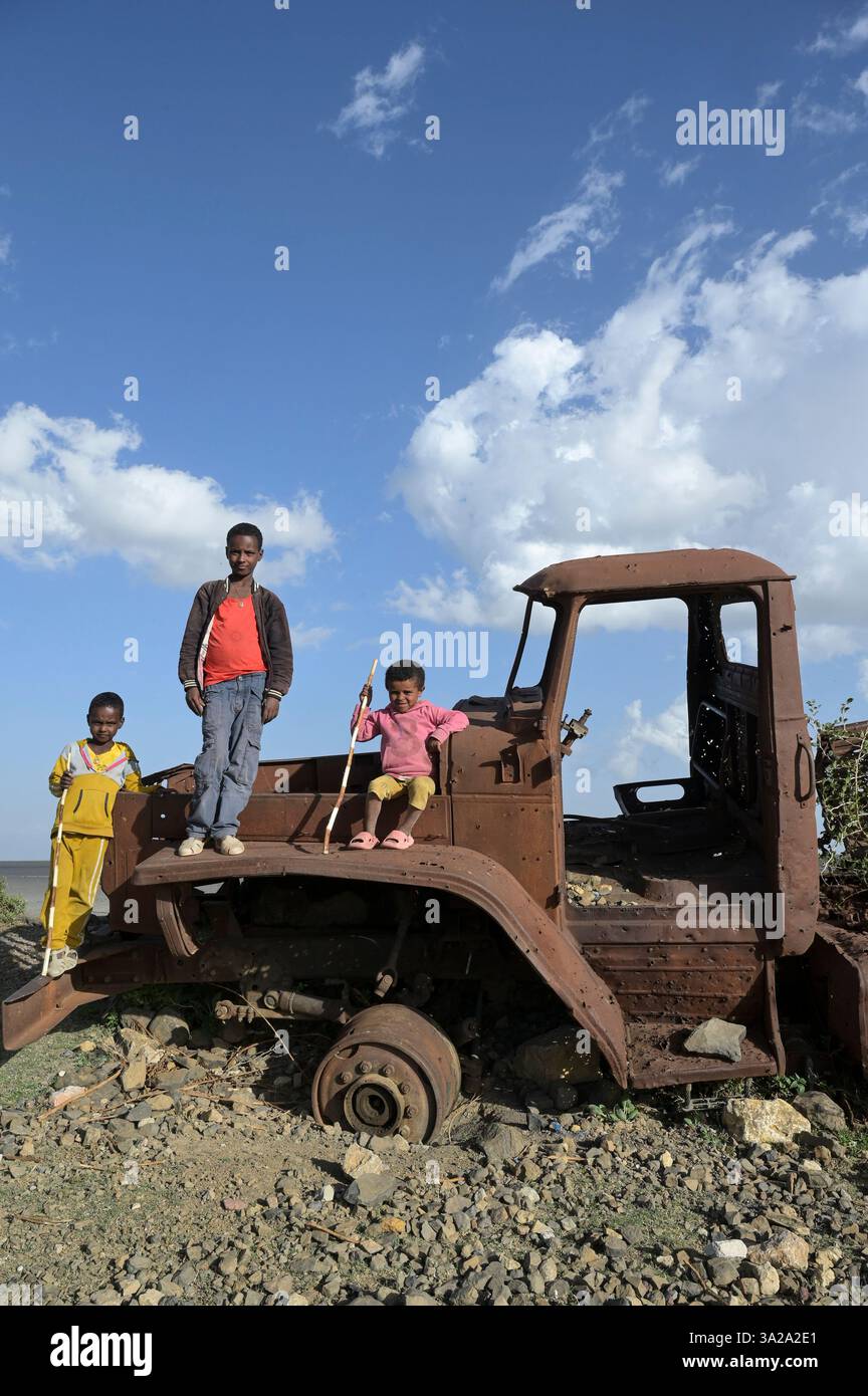 ÄTHIOPIEN, Tigray, Straße nach Mekelle, Tigray Krieg 2020-2022 zwischen Truppen, die mit der äthiopischen Bundesregierung und Eritrea verbündet sind, und der Tigray Volksbefreiungsfront TPLF, Kinder spielen auf zerstörtem russischen Artilleriewagen Ural 4320 der eritreischen Truppen / Äthiopien, Tigray, Folgen des Tigray Kriege 2020-2022, Distrikt Yechila, im Krieg von der TPLF zerstörte Armeefahrzeuge der eritreischen Truppen Stockfoto