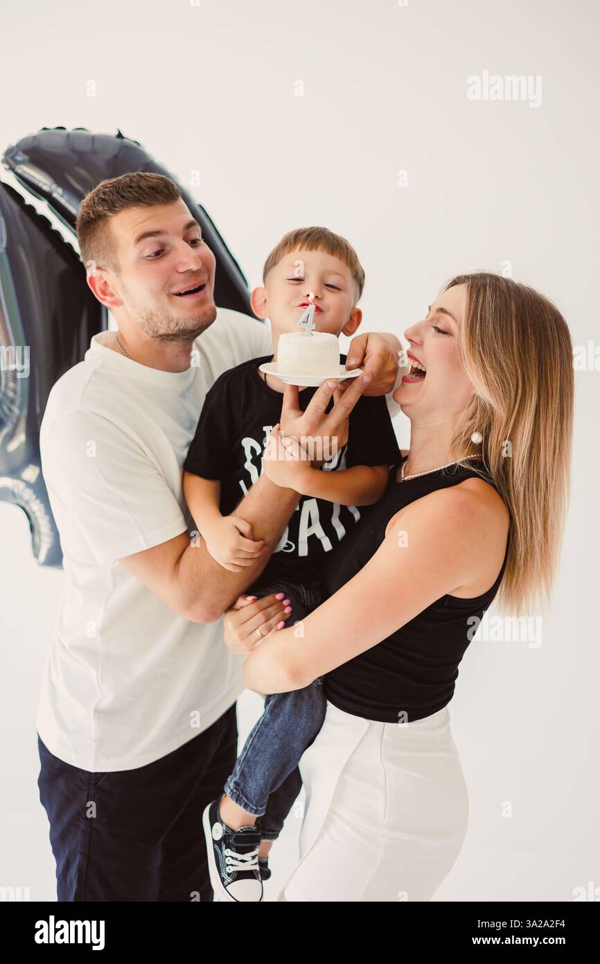 Eine fröhliche Familie feiert gemeinsam mit einer Geburtstagstorte und fängt ihr Lächeln und ihre Liebe ein Stockfoto