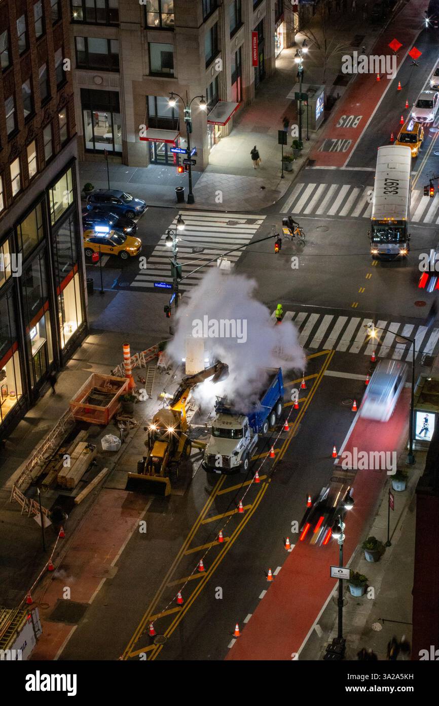 Stadtarbeiter arbeiten rund um die Uhr, um ein Dampfleck an einer großen Kreuzung in Manhattan, New York City, 2025, USA, zu reparieren Stockfoto