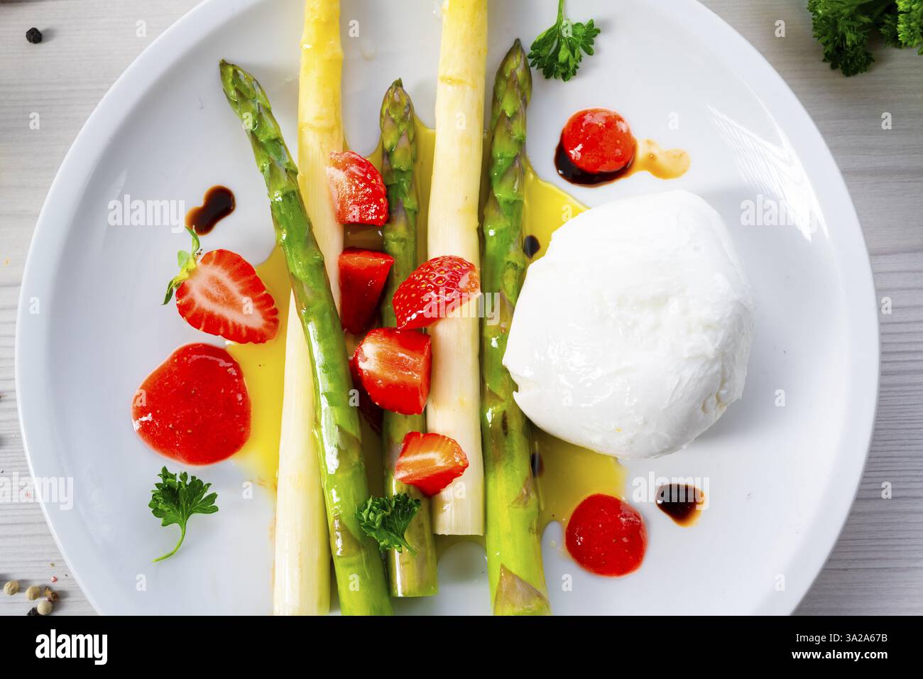 Burrata-Käse mit Spargel und Erdbeeren Stockfoto