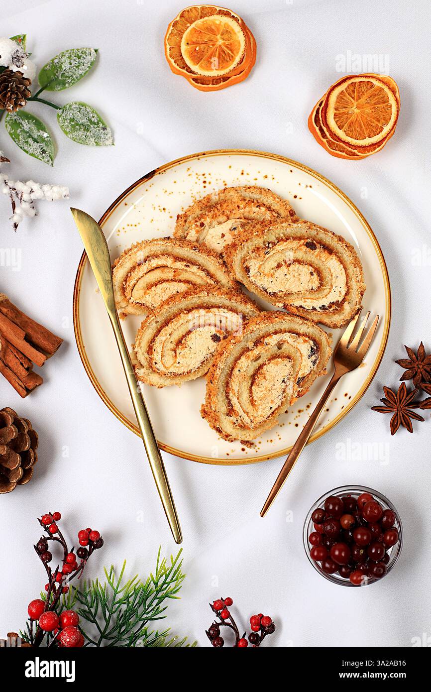 Hausgemachtes Winterdessert, Stollen oder Strudel mit süßer Sahnefüllung, Nüssen, Zimt und Mohn. Konzept für Urlaubsbäckerei, saisonale Leckereien und Stockfoto