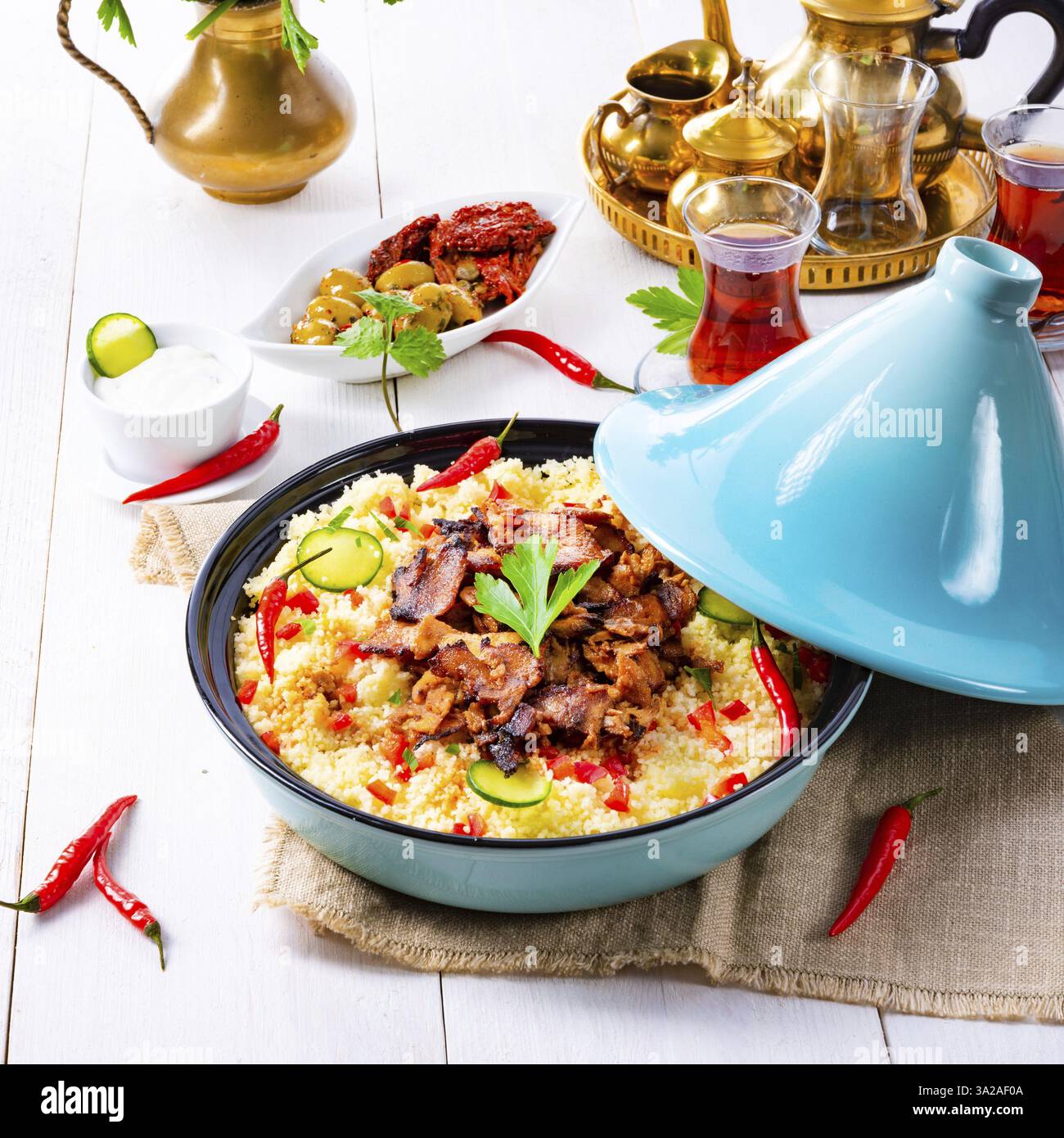 Tajin mit Couscous, Gemüse und Fleisch auf weißem Hintergrund Stockfoto