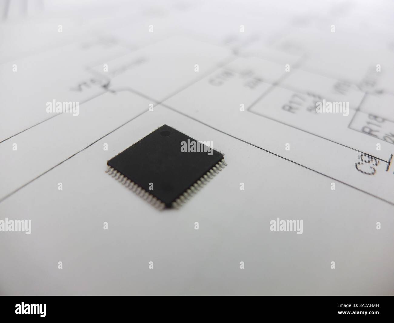 Verschiedene integrierte Schaltungen, Mikrocontroller in DIP-SOIC-TQFP-Gehäusen. Auf der Rückseite befindet sich ein Schaltplan Stockfoto