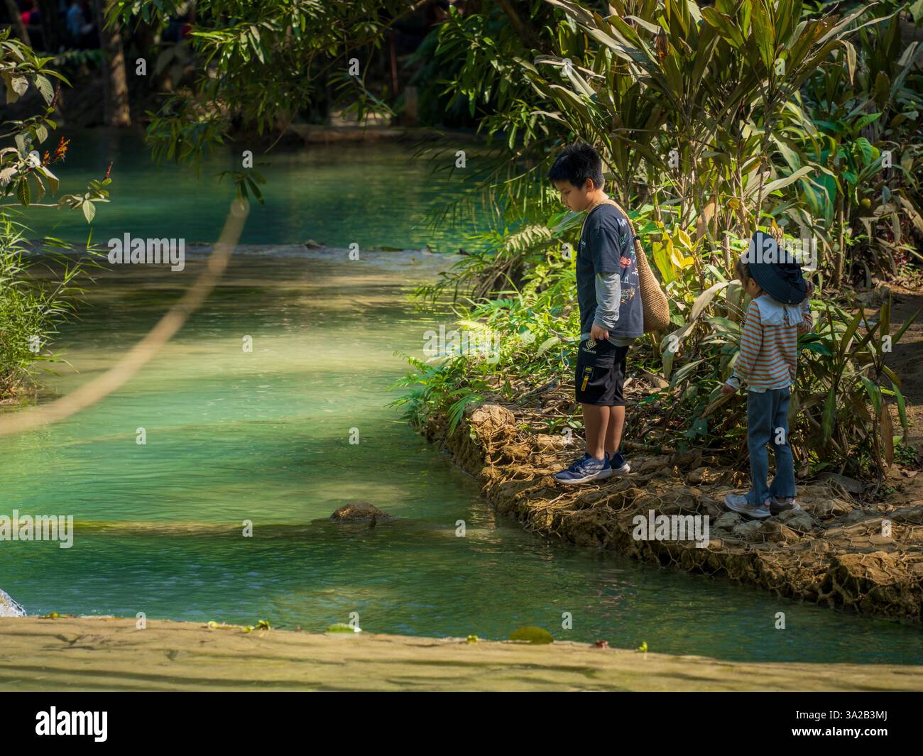 Kinder am Fluss Kuang Si Falls, Luang Prabang, Laos. Natürliches Wasser, tropische Umgebung Stockfoto