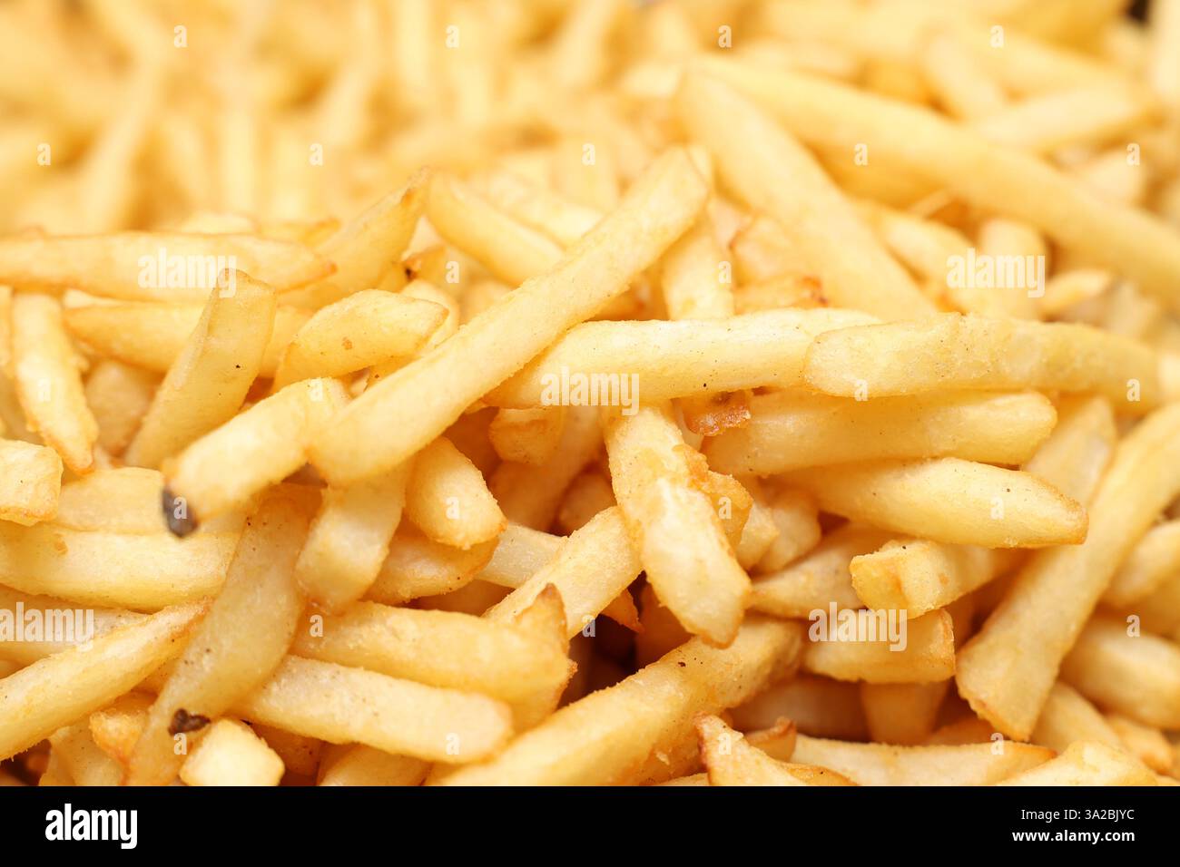 Aus nächster Nähe sehen Sie leckere, goldgewürzte Hot Chips oder Pommes Frites. Hungersnot, ungesunde Essgewohnheiten oder traditionelles Essen zum Mitnehmen. Traditionelles Mitnehmen Stockfoto
