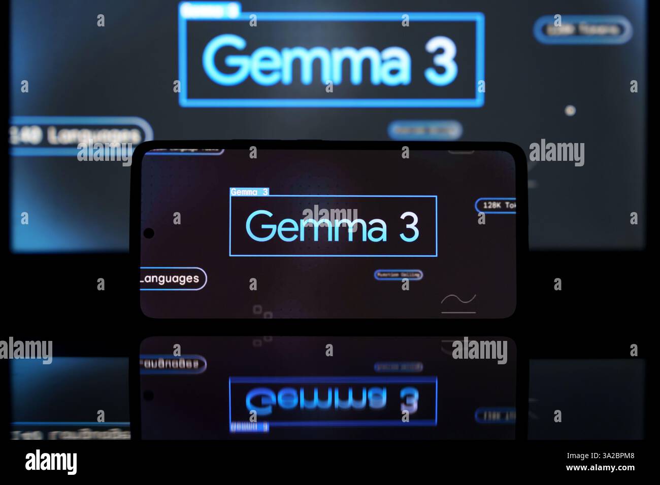 Smartphone-Bildschirm mit Google Gemma 3 AI-Modell, mit einem größeren Bildschirm im Hintergrund. Das Bild betont künstliche Intelligenz und digitale Stockfoto