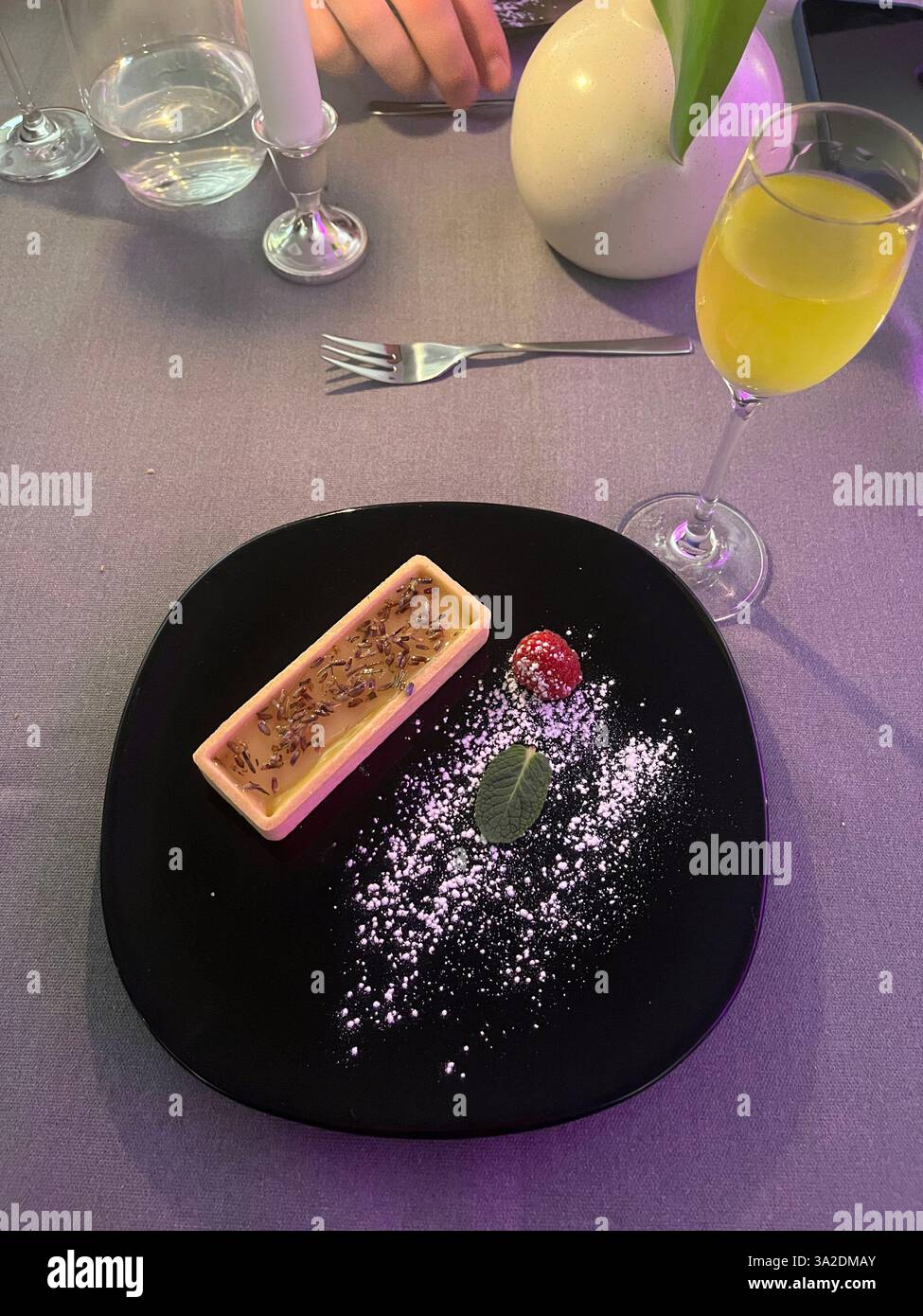 Ein romantisches Abendessen mit einer köstlichen Zitronentorte als Dessert, begleitet von einem erfrischenden Getränk, schafft das perfekte Ambiente. Stockfoto