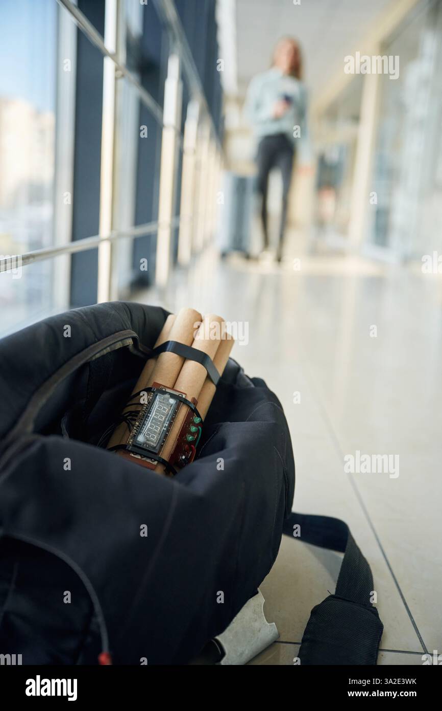 Nahaufnahme der Zeitbombe in der Tasche. Frau läuft im Hintergrund. Stockfoto