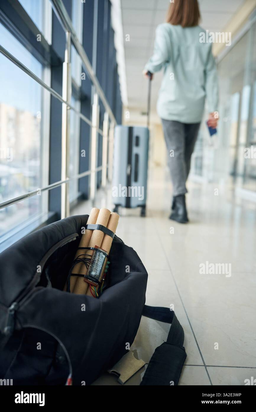 Nahaufnahme der Zeitbombe in der Tasche. Frau läuft im Hintergrund. Stockfoto