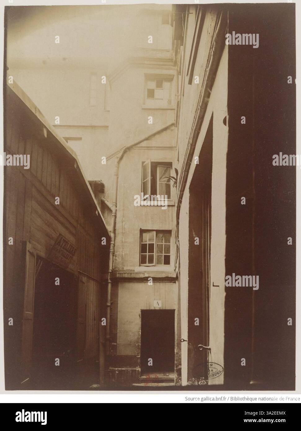 Eugène Atgets Foto der Rue Chanoinesse 18 zeigt den Innenhof eines Pariser Gebäudes. Das Bild erfasst die architektonische Struktur und räumliche Organisation des Raumes. Stockfoto