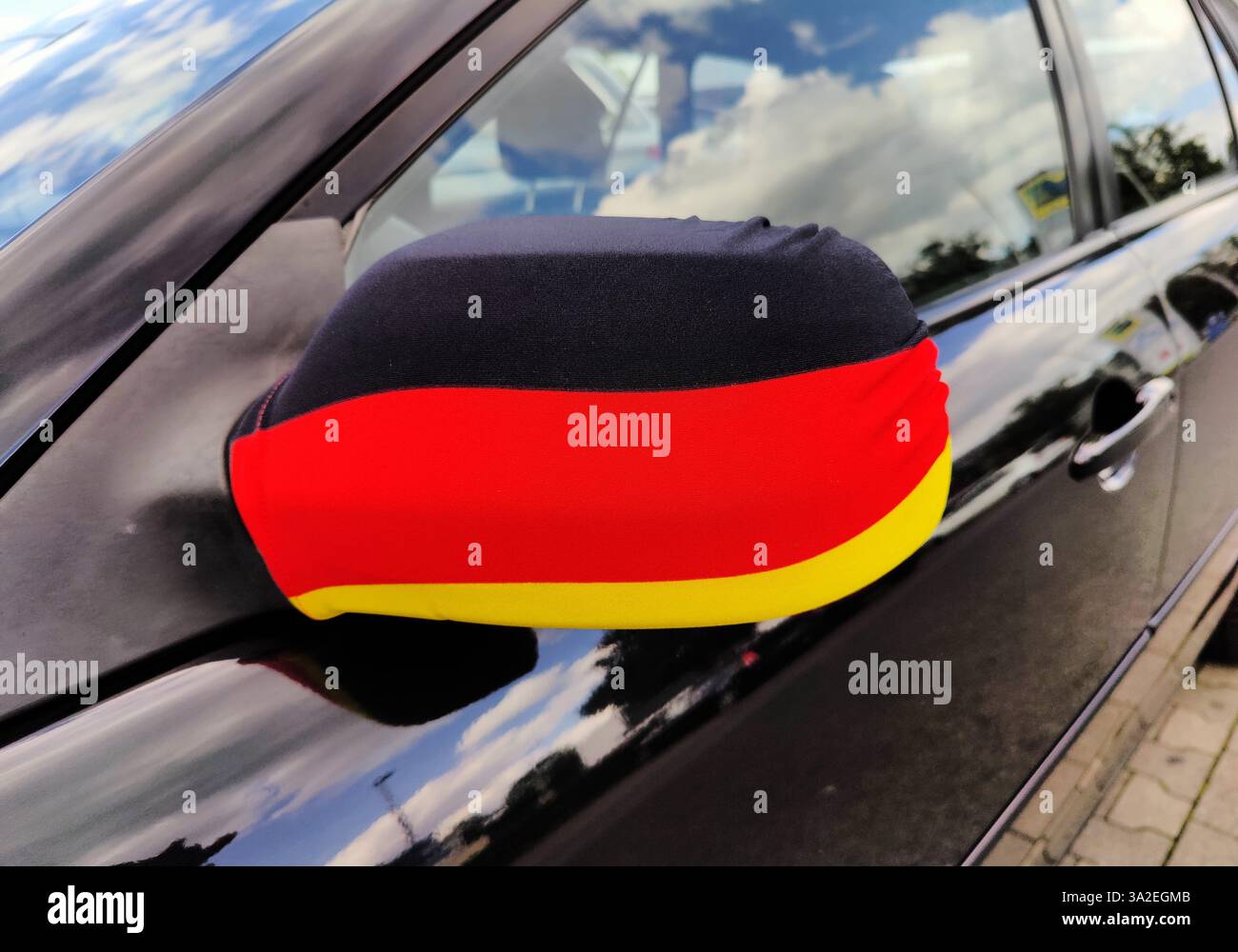 Schwarz, rot und Gold, Abdeckung auf dem Außenspiegel eines Autos für die Fußball-Europameisterschaft 2024, Deutschland Stockfoto