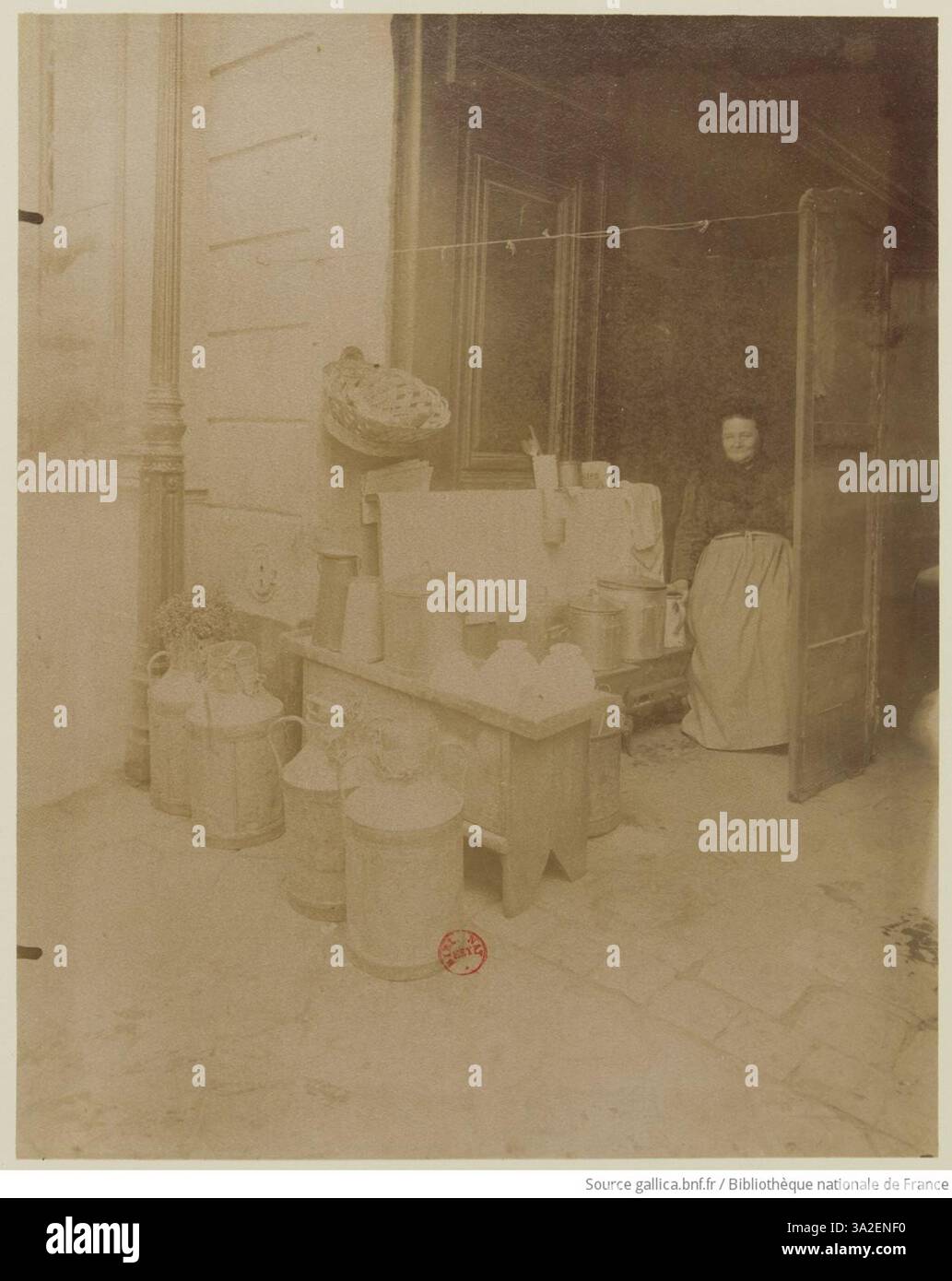 Eugène Atgets Foto zeigt einen Kaffeehändler, auch bekannt als „la laitière“, in der Rue Mouffetard in Paris, der einen Moment des Straßenhandels im späten 19. Jahrhundert feststellt. Stockfoto