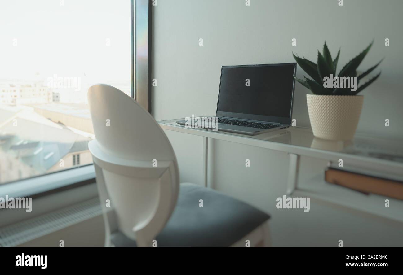 Laptop am Fenster in einem Büroarbeitsplatz. Stockfoto