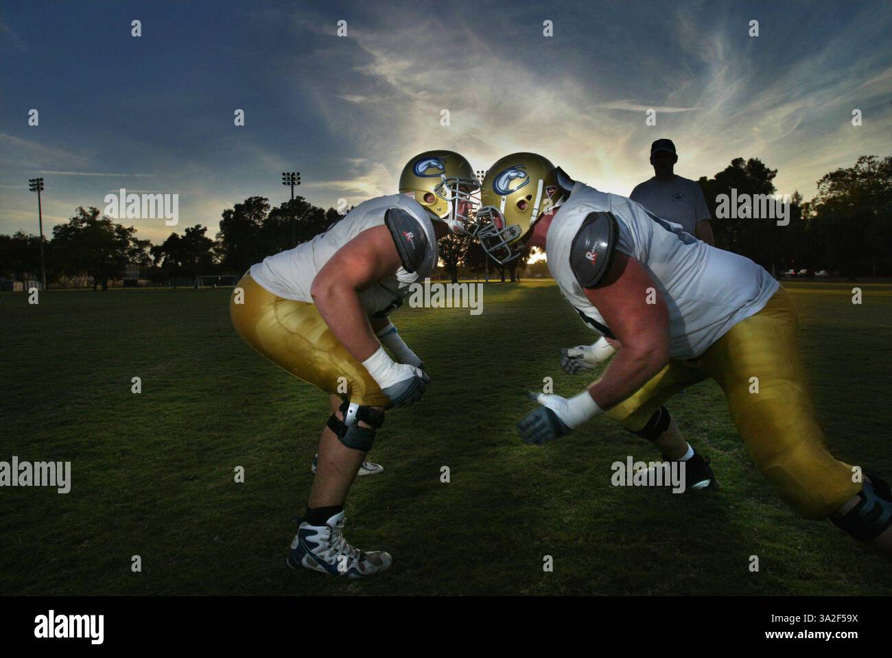 Die Brüder Brad Right und Cory Lekkerkerker cq üben mit dem Line Coach während eines Trainings in U.C. Davis. Sie sind 330-Kilo-Offensive-Tackles, die angewiesen sind, das Viertel wieder am Leben zu erhalten. Sie sind sehr nah, wenn auch ein Jahr auseinander, und machen alles zusammen. Foto am Dienstag, 16. September 2003. (Vermerk: © Sacramento Bee/ZUMAPRESS.com) Stockfoto