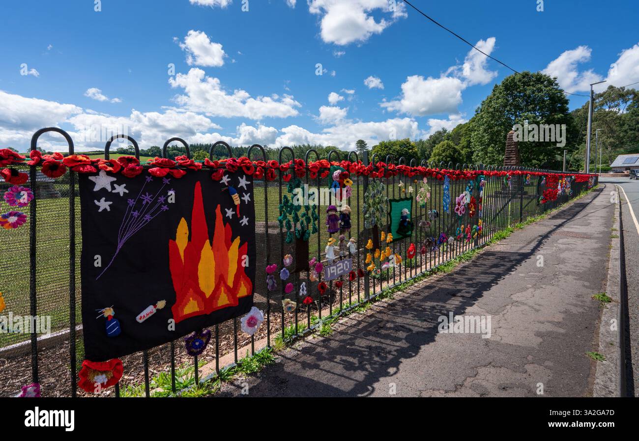 Der Schulzaun schmückte zahlreiche Mohnblumen und andere Strickgegenstände zur Unterstützung des Mohntags Stockfoto